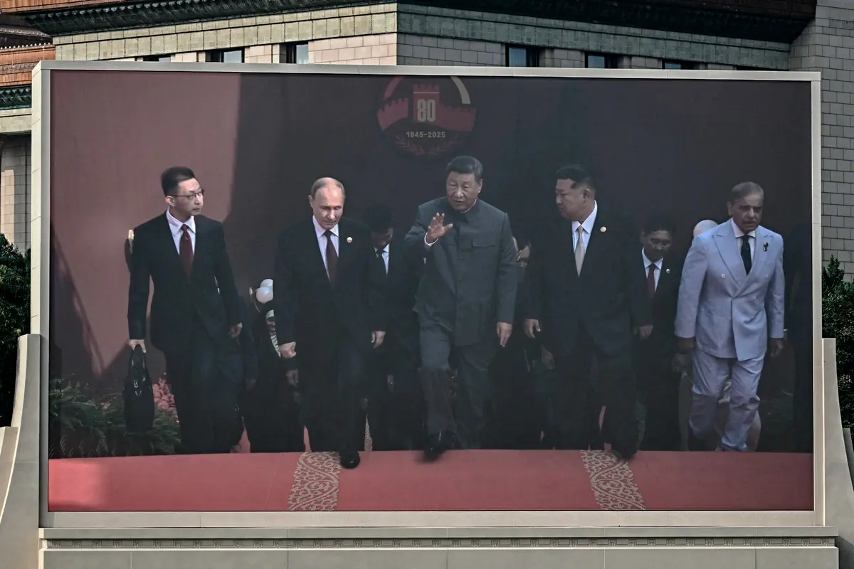Una pantalla muestra al líder chino Xi Jinping (C) caminando junto al presidente ruso Vladimir Putin (centro izq.) y al líder norcoreano Kim Jong Un (centro dcha.) antes de un desfile militar que conmemora el 80.º aniversario de la victoria sobre Japón y el fin de la Segunda Guerra Mundial, en la plaza de Tiananmen, Beijing, el 3 de septiembre de 2025. (Pedro Pardo/AFP a través de Getty Images)