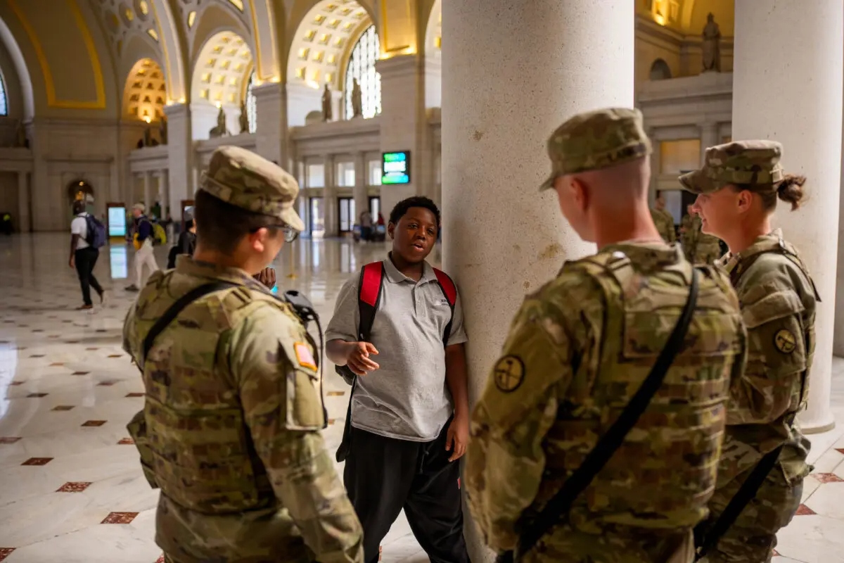 Miembros de la Guardia Nacional charlan con jóvenes visitantes de la Union Station de Washington el 8 de septiembre de 2025. (Andrew Harnik/Getty Images)