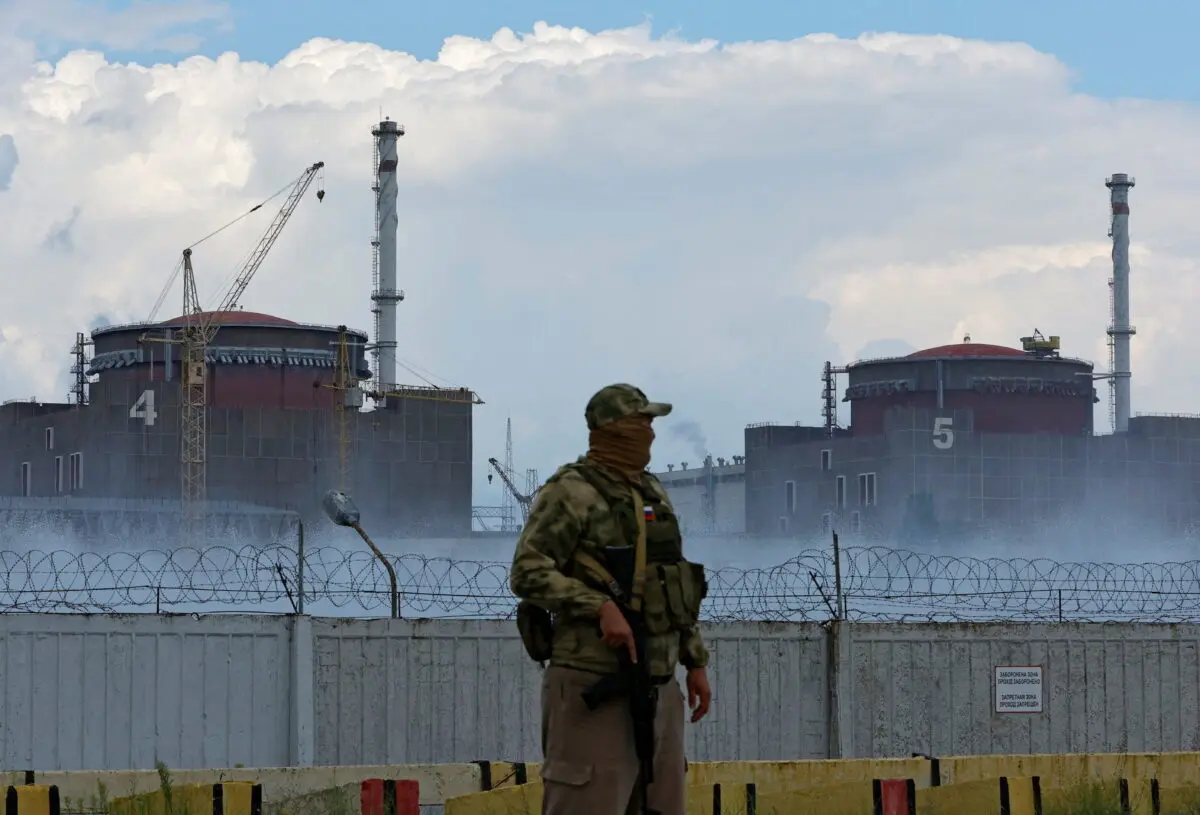 Un militar con una bandera rusa en su uniforme hace guardia cerca de la central nuclear de Zaporizhia, en las afueras de la ciudad de Enerhodar, controlada por Rusia, en la región de Zaporizhia, Ucrania, el 4 de agosto de 2022. (Alexander Ermochenko/Reuters)