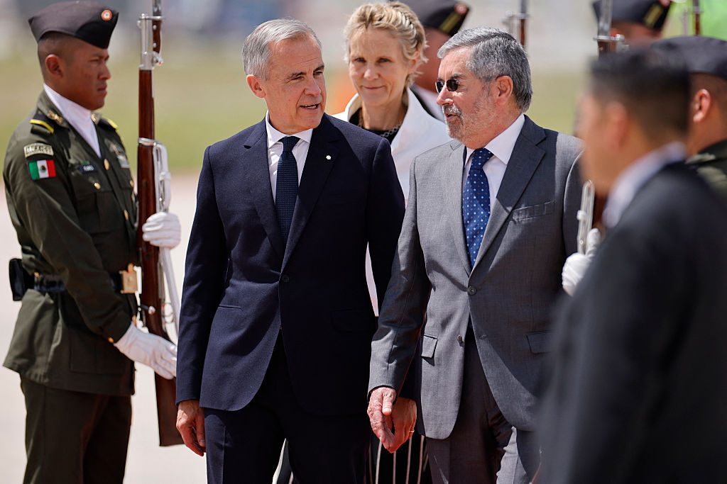 El primer ministro de Canadá, Mark Carney (izq.), acompañado por su esposa, Diana Fox (centro, atrás), pasa revista a la guardia de honor junto al secretario de Relaciones Exteriores de México, Juan Ramón de la Fuente, a su llegada al Aeropuerto Internacional Felipe Ángeles en Zumpango, Estado de México, México, el 18 de septiembre de 2025. El presidente de México recibirá al líder de Canadá para las conversaciones comerciales el jueves, en un intento por sortear la guerra arancelaria iniciada por Donald Trump, a pesar de la existencia de un acuerdo de libre comercio trilateral. (Foto de RODRIGO OROPEZA/AFP vía Getty Images)