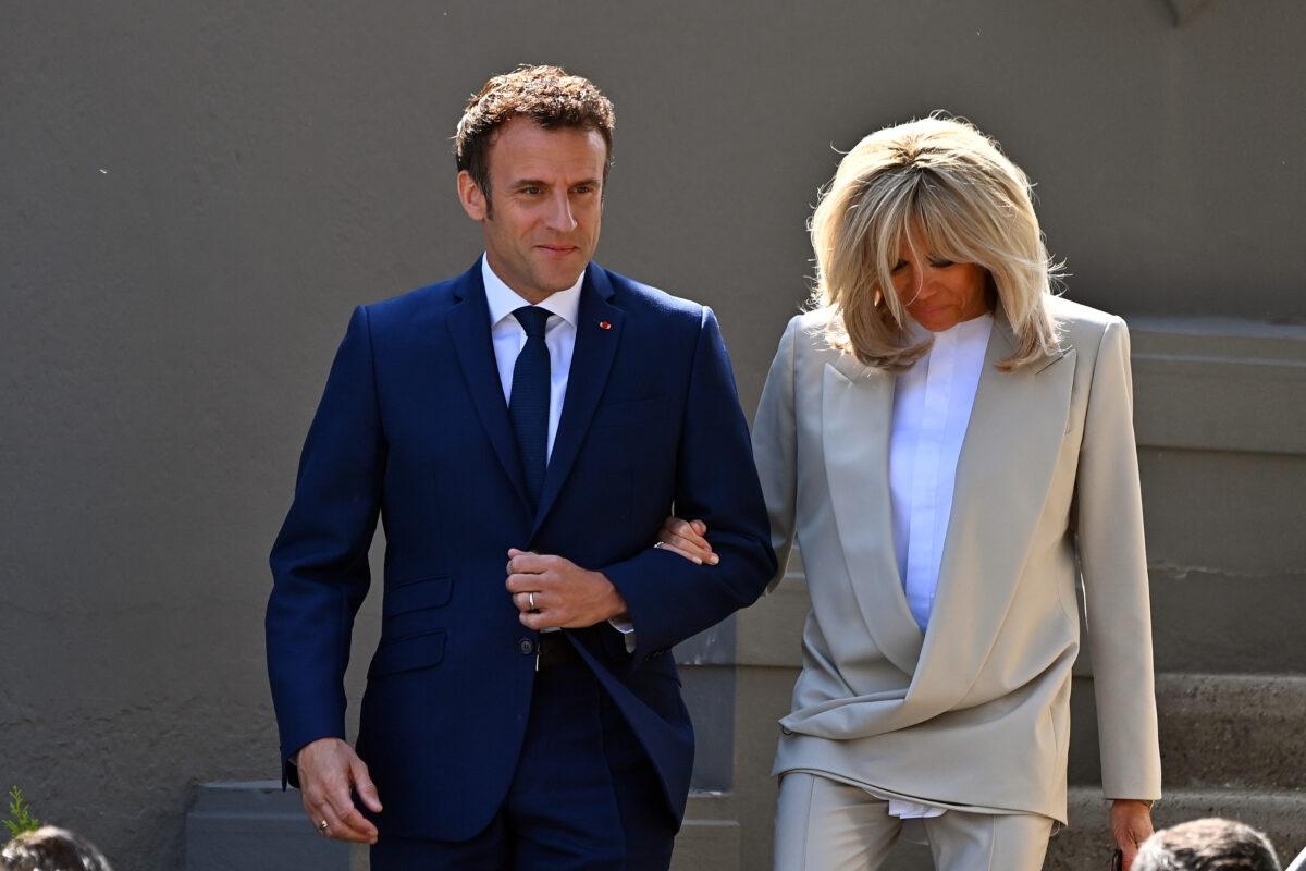 El presidente francés Emmanuel Macron saluda a los votantes al salir de su casa con su esposa Brigitte Macron para ir a votar en Le Touquet-Paris-Plage, Francia, el 24 de abril de 2022. (Aurelien Meunier/Getty Images)