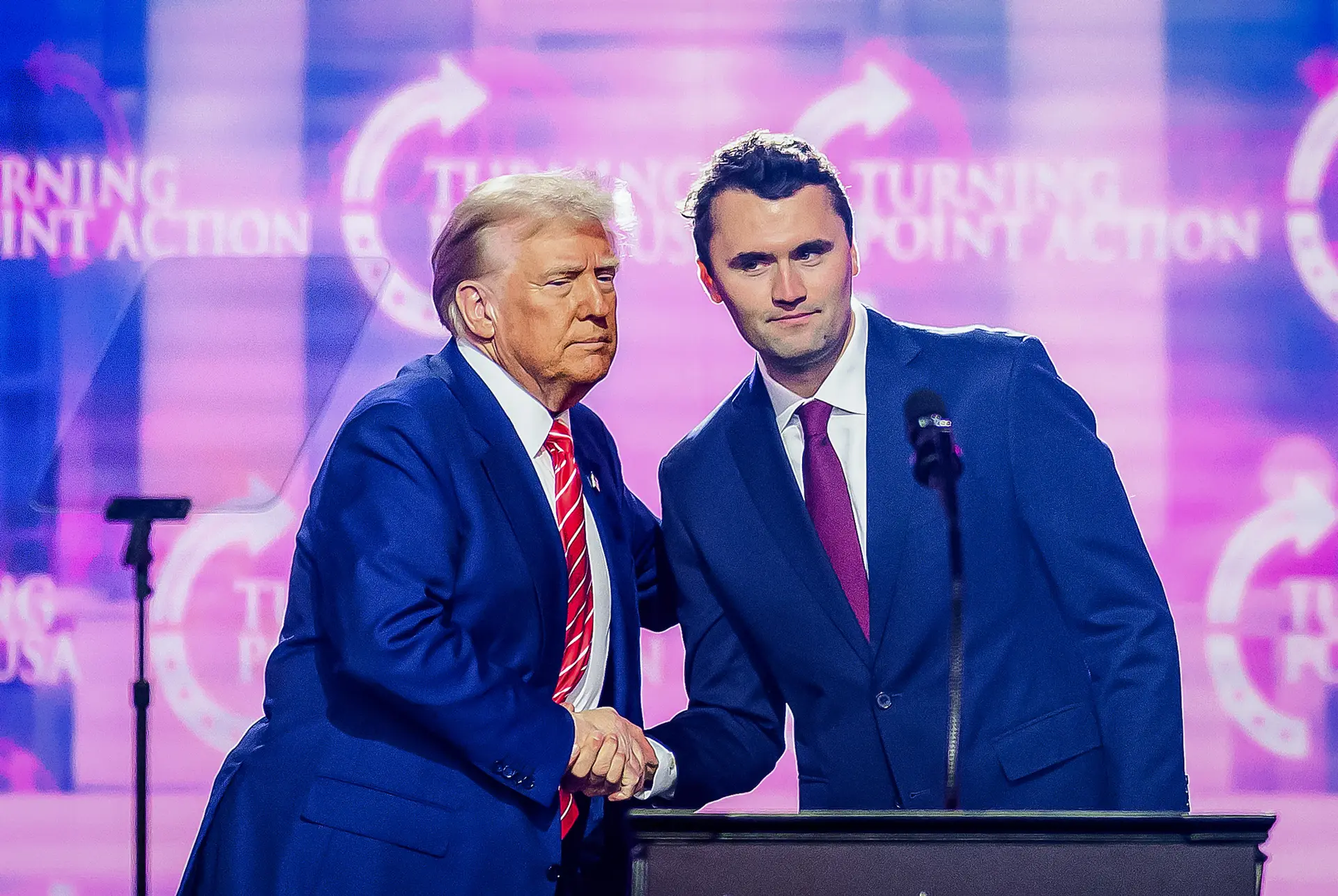 El influyente conservador Charlie Kirk (derecha) estrecha la mano del presidente Donald Trump mientras habla en el escenario del America Fest 2024 en Phoenix el 22 de diciembre de 2024. (Josh Edelson/AFP vía Getty Images)
