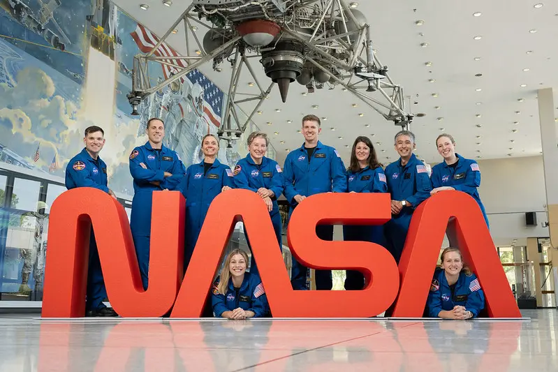La 24.ª promoción de candidatos a astronautas de la NASA posa junto a una escultura del logotipo "gusano" de la NASA en el Centro Espacial Johnson de Houston, Texas, antes de ser presentada al país el 22 de septiembre de 2025. (Cortesía de la NASA).