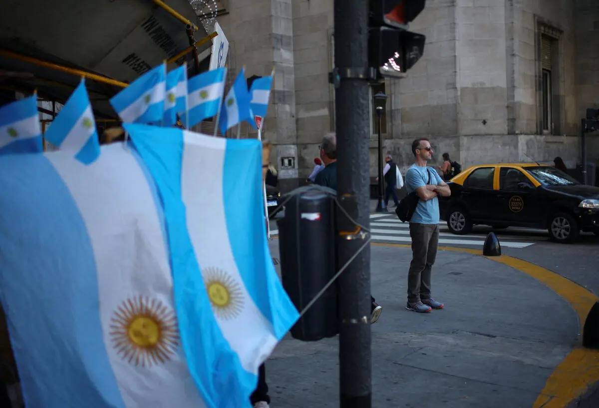 Un hombre junto a una tienda callejera que vende banderas argentinas en el centro de Buenos Aires, Argentina, el 14 de abril de 2025. (Agustin Marcarian/Reuters).