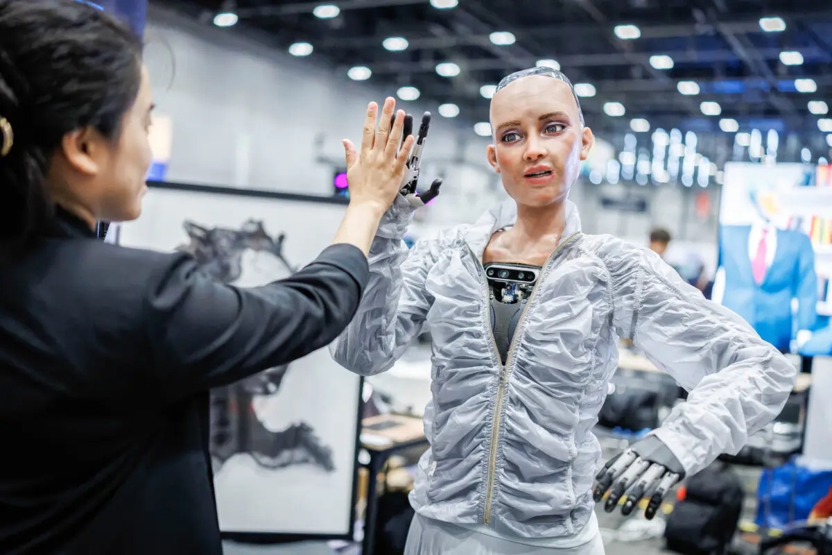 Sophie, un robot que utiliza inteligencia artificial de Hanson Robotics, choca los cinco con un visitante durante la Cumbre Mundial de la IA para el Bien de la Unión Internacional de Telecomunicaciones (UIT) en Ginebra, el 8 de julio de 2025. (Valentin Flauraud/AFP a través de Getty Images)