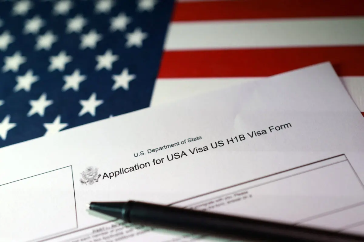 Una bandera estadounidense y una solicitud de visa H-1B, en esta foto ilustrativa tomada el 22 de septiembre de 2025. Dado Ruvic/Reuters