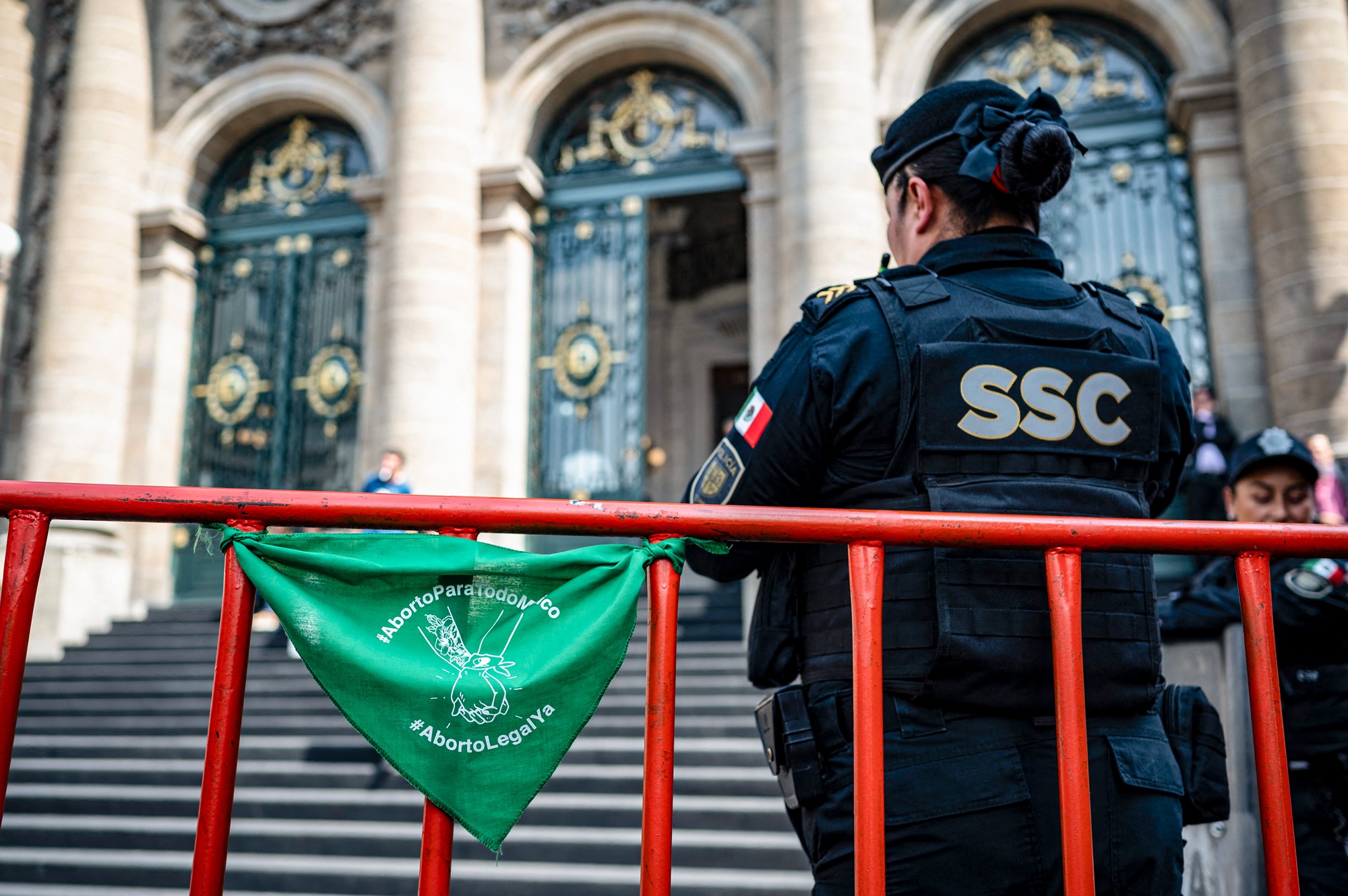 Un oficial de policía monta guardia junto a una bufanda verde (símbolo proabortista) con la inscripción «Aborto legal ya», colocada por activistas proabortistas frente a la sede del Congreso de la Ciudad de México el 7 de noviembre de 2024. (Yuri Cortez/AFP vía Getty Images).