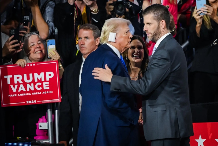 El entonces candidato presidencial republicano Donald Trump saluda a su hijo, Eric Trump, en el segundo día de la Convención Nacional Republicana en el Fiserv Forum de Milwaukee, Wisconsin, el 16 de julio de 2024, tres días después del intento de asesinato del expresidente en Butler, Pensilvania. (Leon Neal/Getty Images)