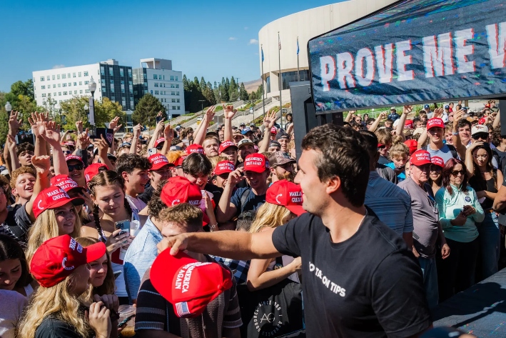 El influyente conservador Charlie Kirk lanza gorras de MAGA al llegar para dar una charla en la Universidad de Nevada en Reno durante su gira "You're Being Brainwashed" (Te están lavando el cerebro), el 8 de octubre de 2024. (Andri Tambunan/AFP a través de Getty Images)
