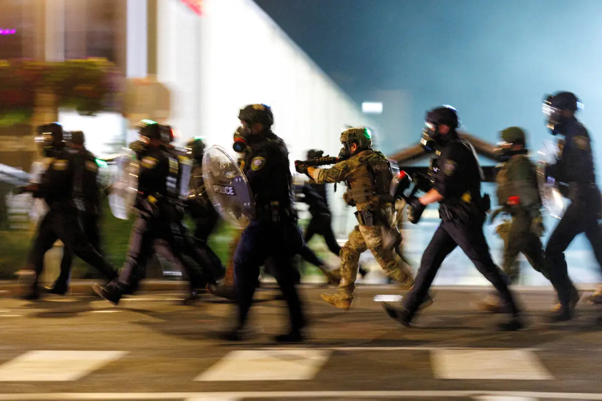Agentes del Servicio de Inmigración y Control de Aduanas cargan contra manifestantes frente a un centro de detención en Portland, Oregón, el 1 de septiembre de 2025. (John Rudoff/Reuters)