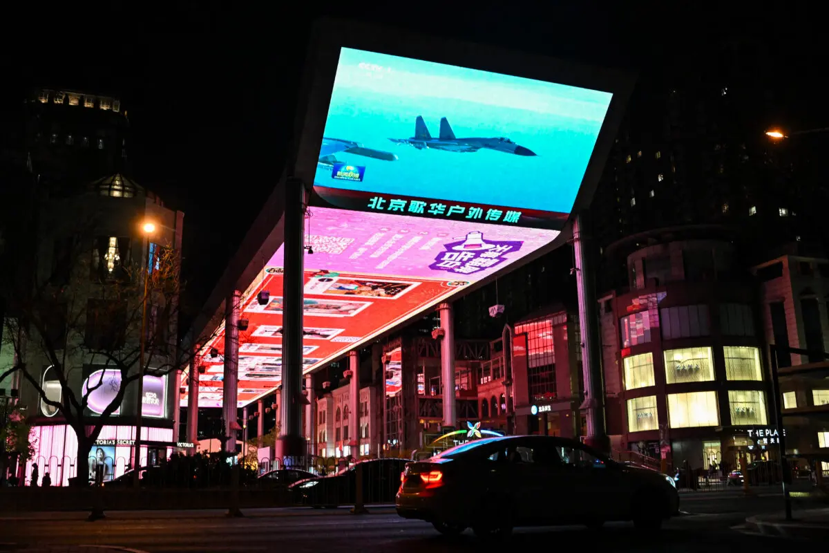 Una gran pantalla transmite noticias sobre las maniobras militares de China alrededor de Taiwán, fuera de un centro comercial en Beijing, el 1 de abril de 2025. (Adek Berry/AFP vía Getty Images)