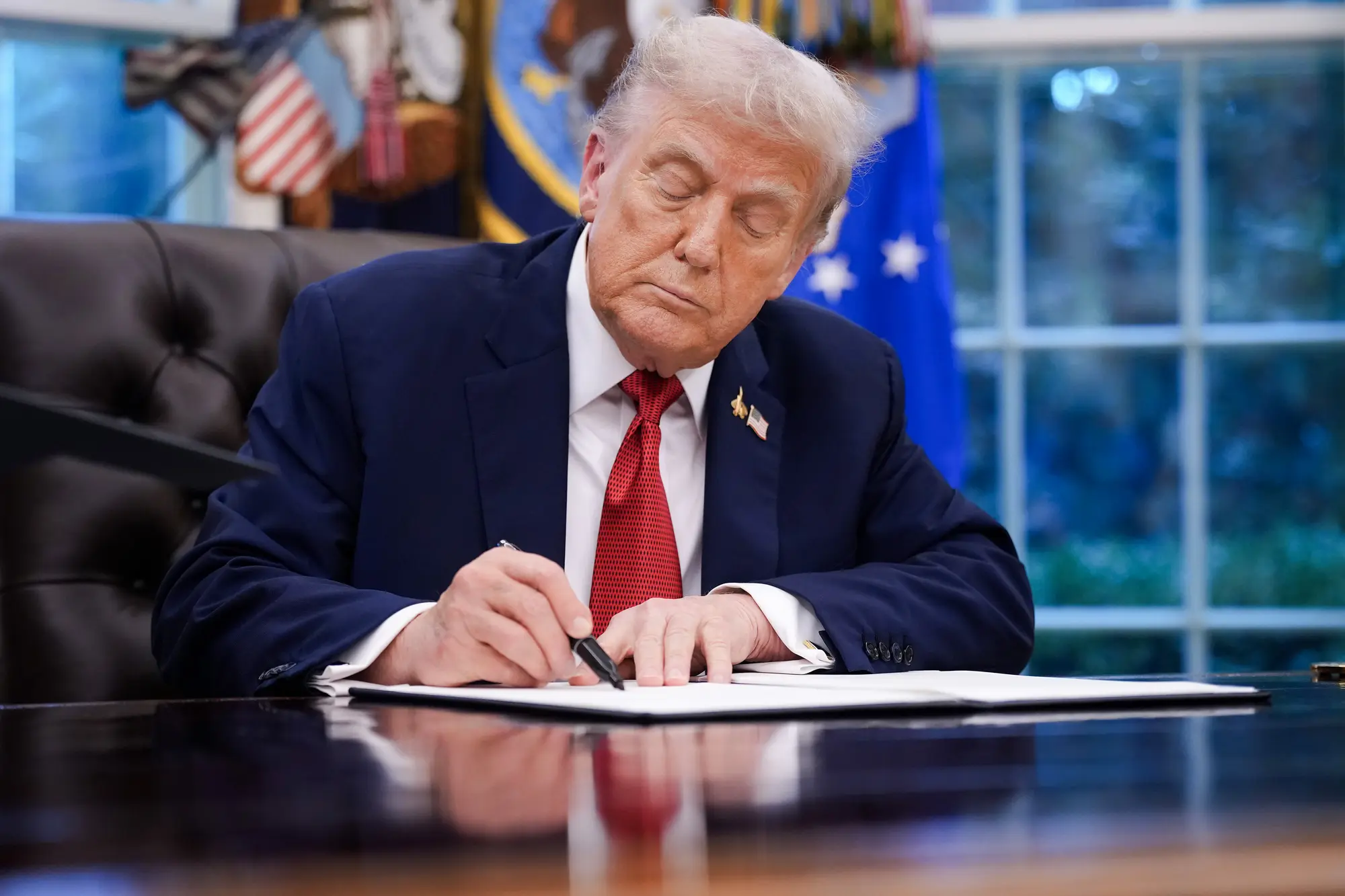 <em>El presidente Donald Trump firma una orden ejecutiva en el Despacho Oval el 25 de septiembre de 2025. Días antes, el presidente designó a Antifa como grupo terrorista nacional y posteriormente firmó un memorándum para desmantelar las redes terroristas de izquierda en Estados Unidos. Andrew Harnik/Getty Images</em>
