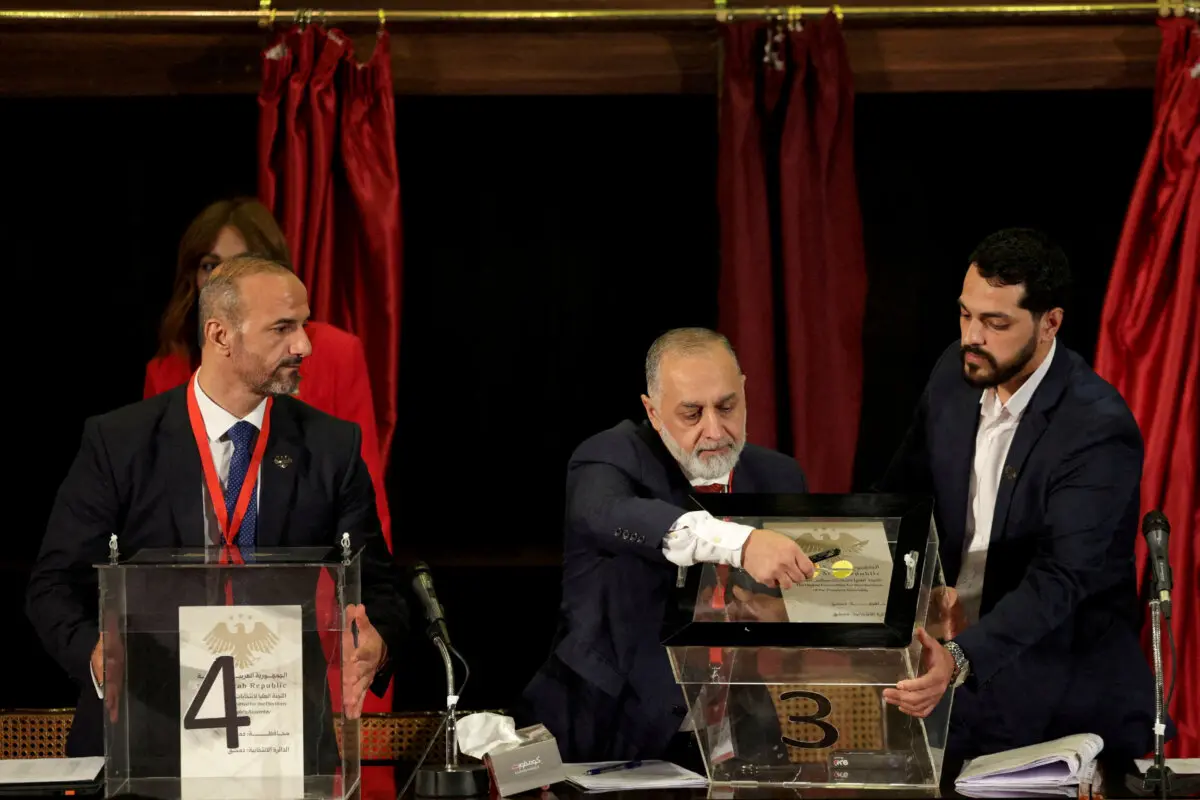 Un miembro de los colegios electorales abre la urna durante la votación para seleccionar un candidato para el nuevo Parlamento sirio desde que fue derrocado el gobierno de Bashar al-Assad, en Damasco, Siria, el 5 de octubre de 2025. (Khalil Ashawi/Reuters)