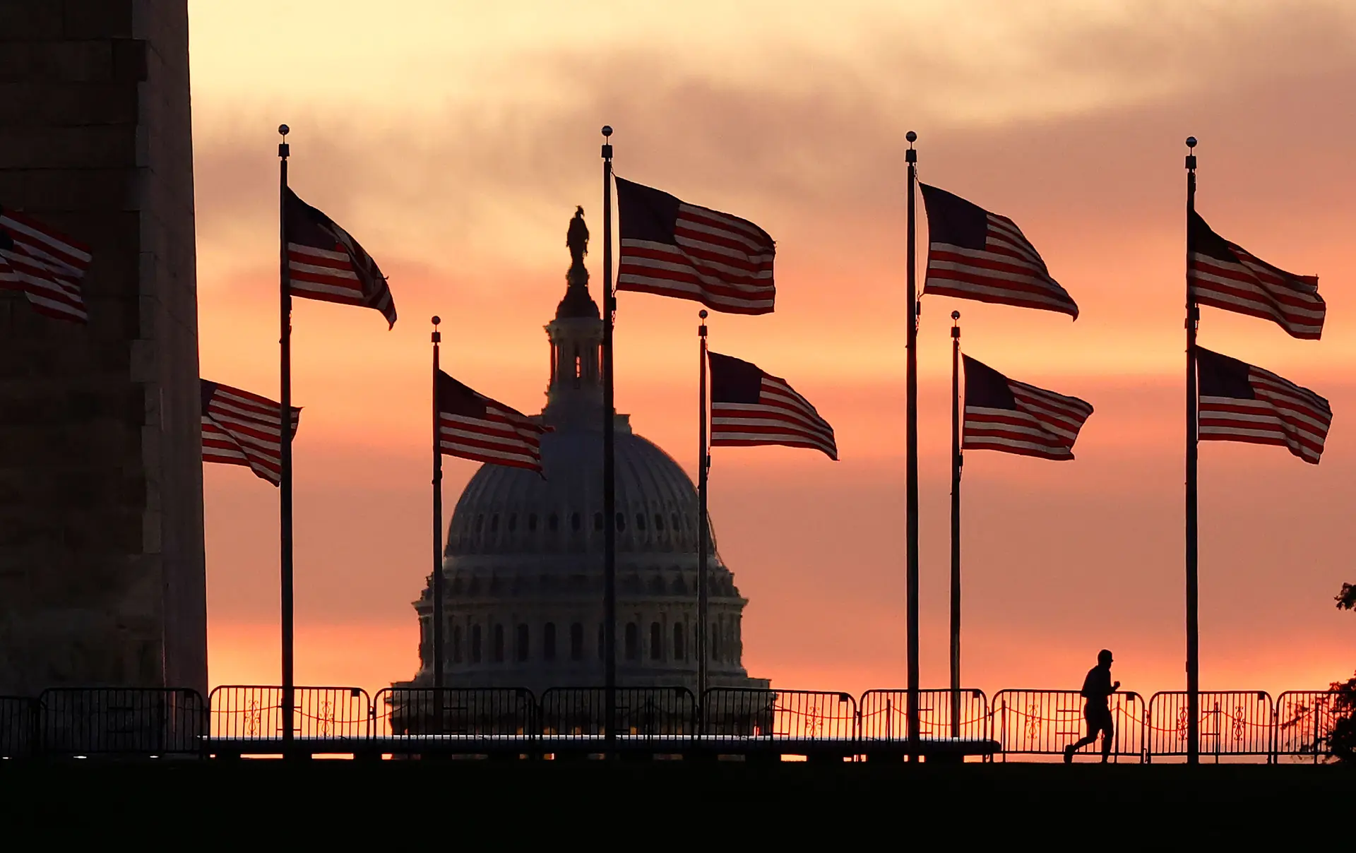 Una persona corre cerca del Monumento a Washington con el Capitolio de los Estados Unidos al fondo al amanecer en Washington el 1 de octubre de 2025. (Kevin Dietsch/Getty Images)