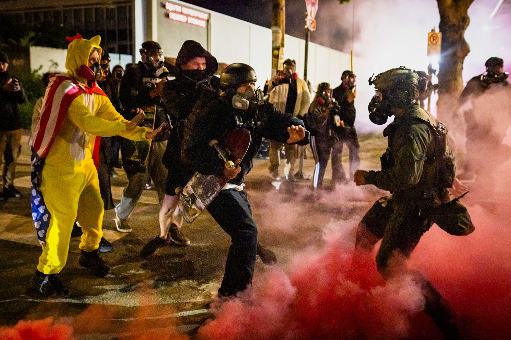 Un miembro de Antifa devuelve una bomba de humo lanzada por agentes federales frente a las oficinas del Servicio de Inmigración y Control de Aduanas en Portland, Oregón, el 5 de octubre de 2025. (John Fredricks/The Epoch Times).