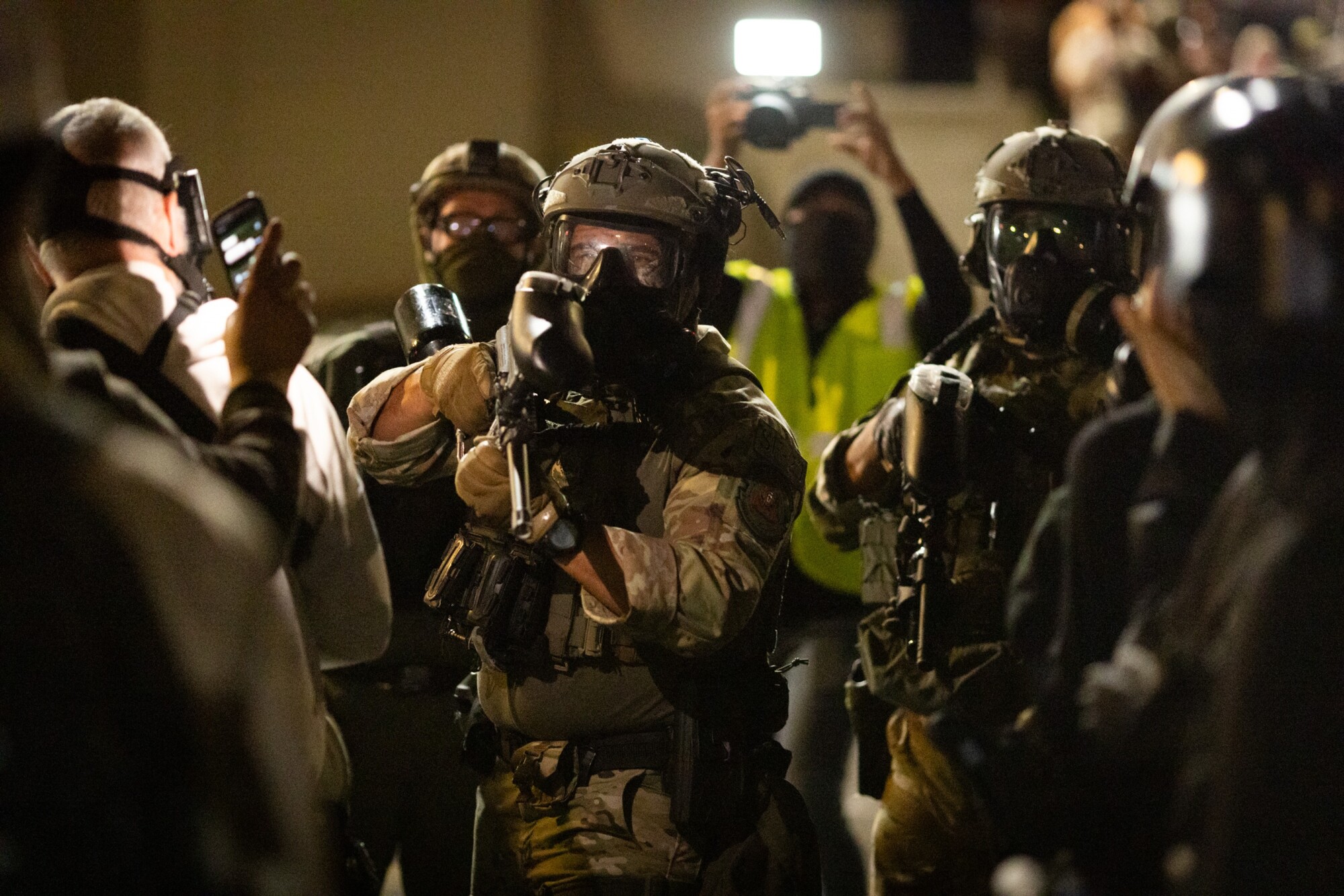 Un agente federal se prepara para disparar balas de pimienta contra los manifestantes frente a las oficinas del Servicio de Inmigración y Control de Aduanas en Portland, Oregón, el 4 de octubre de 2025. (John Fredricks/The Epoch Times).