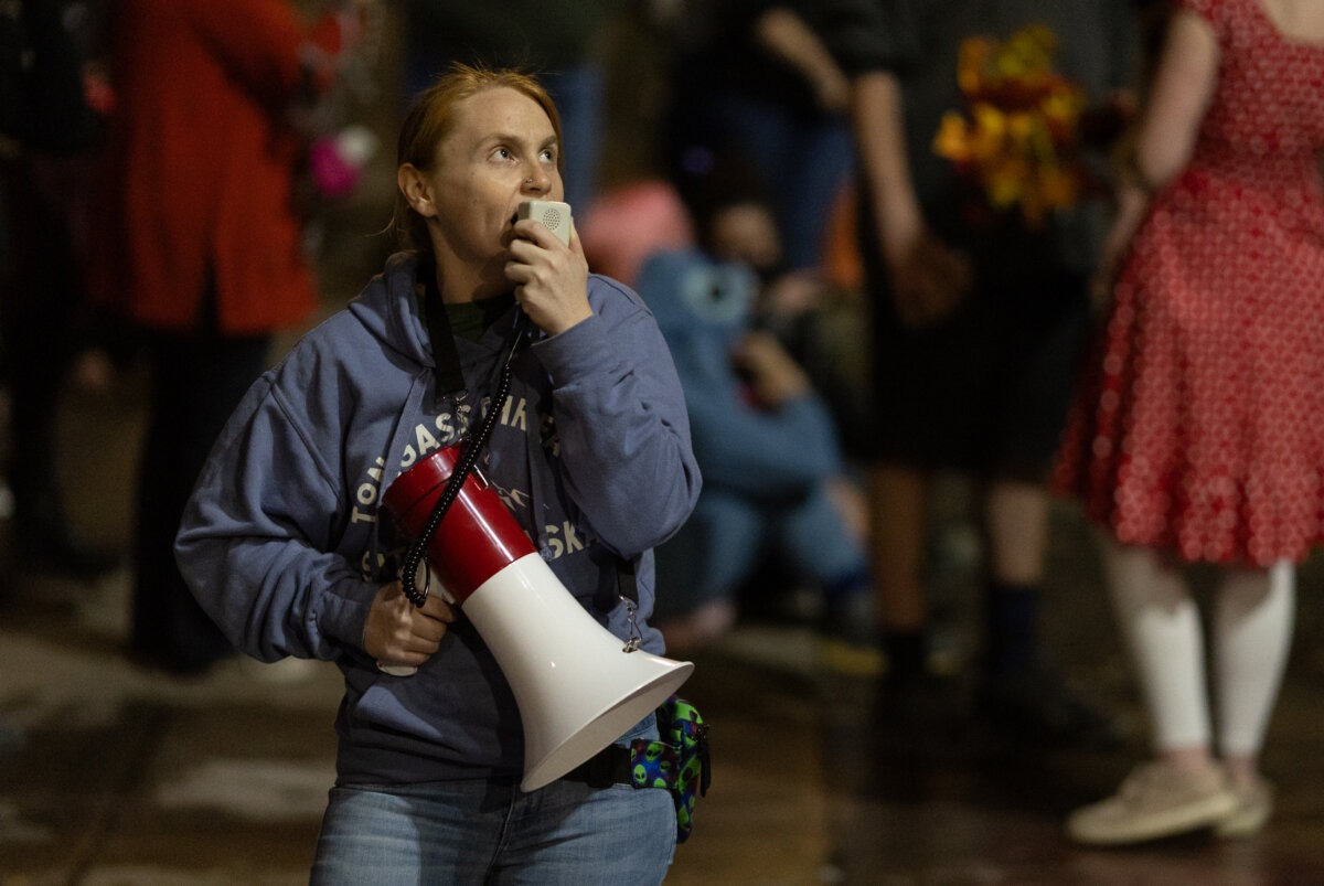Un manifestante grita con un megáfono frente a las oficinas del Servicio de Inmigración y Control de Aduanas en Portland, Oregón, el 4 de octubre de 2025. (John Fredricks/The Epoch Times).