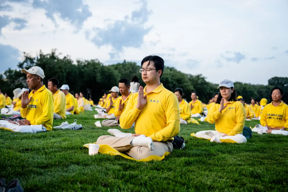 Practicantes de Falun Dafa antes de participar en una vigilia con velas en memoria de los practicantes de Falun Gong que fueron perseguidos hasta la muerte en China por el Partido Comunista Chino, en Washington, el 17 de julio de 2025. (Madalina Kilroy/The Epoch Times)