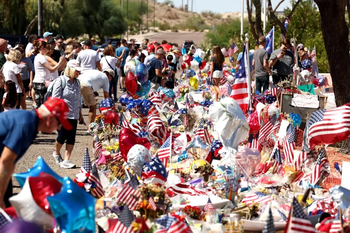 La gente se reúne en un memorial improvisado en honor al fundador de Turning Point USA, Charlie Kirk, frente a la sede de la organización en Phoenix, Arizona, el 20 de septiembre de 2025. (Charly Triballeu/AFP a través de Getty Images)