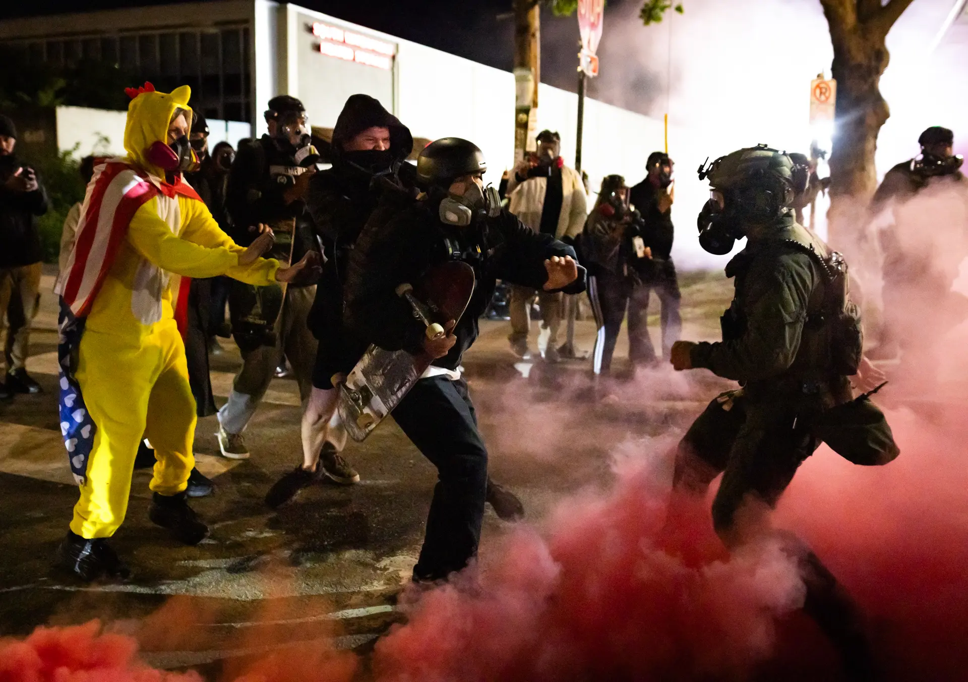 Un miembro de ANTIFA patea una bomba de humo lanzada por agentes federales en su dirección frente a las oficinas de Inmigración y Control de Aduanas en Portland, Oregón, el 5 de octubre de 2025. (John Fredricks/The Epoch Times)