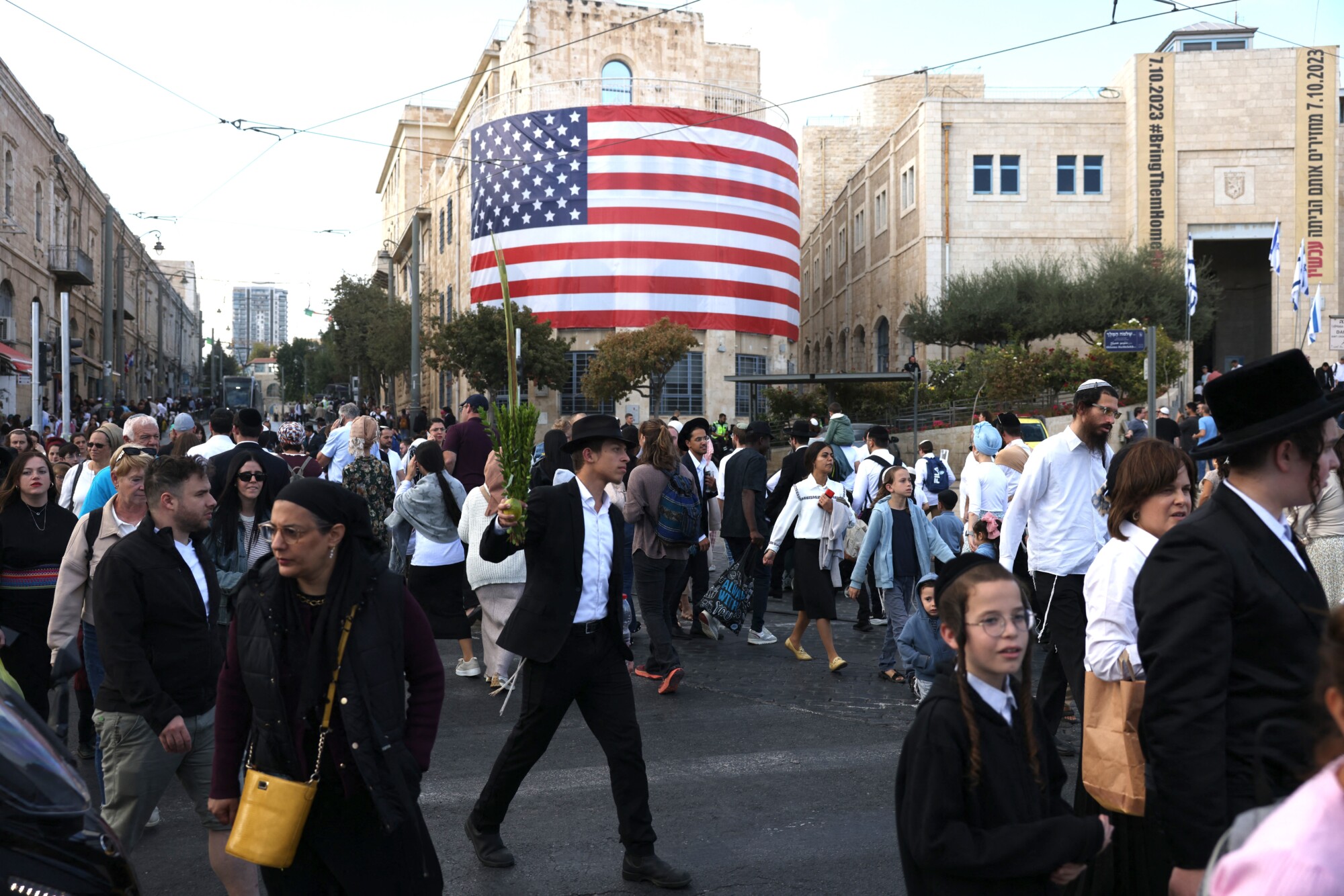Israelíes pasan junto a una bandera estadounidense en el centro de Jerusalén antes de la llegada del presidente estadounidense Donald Trump, el 12 de octubre de 2025. (Ahmad Gharabli/AFP a través de Getty Images)