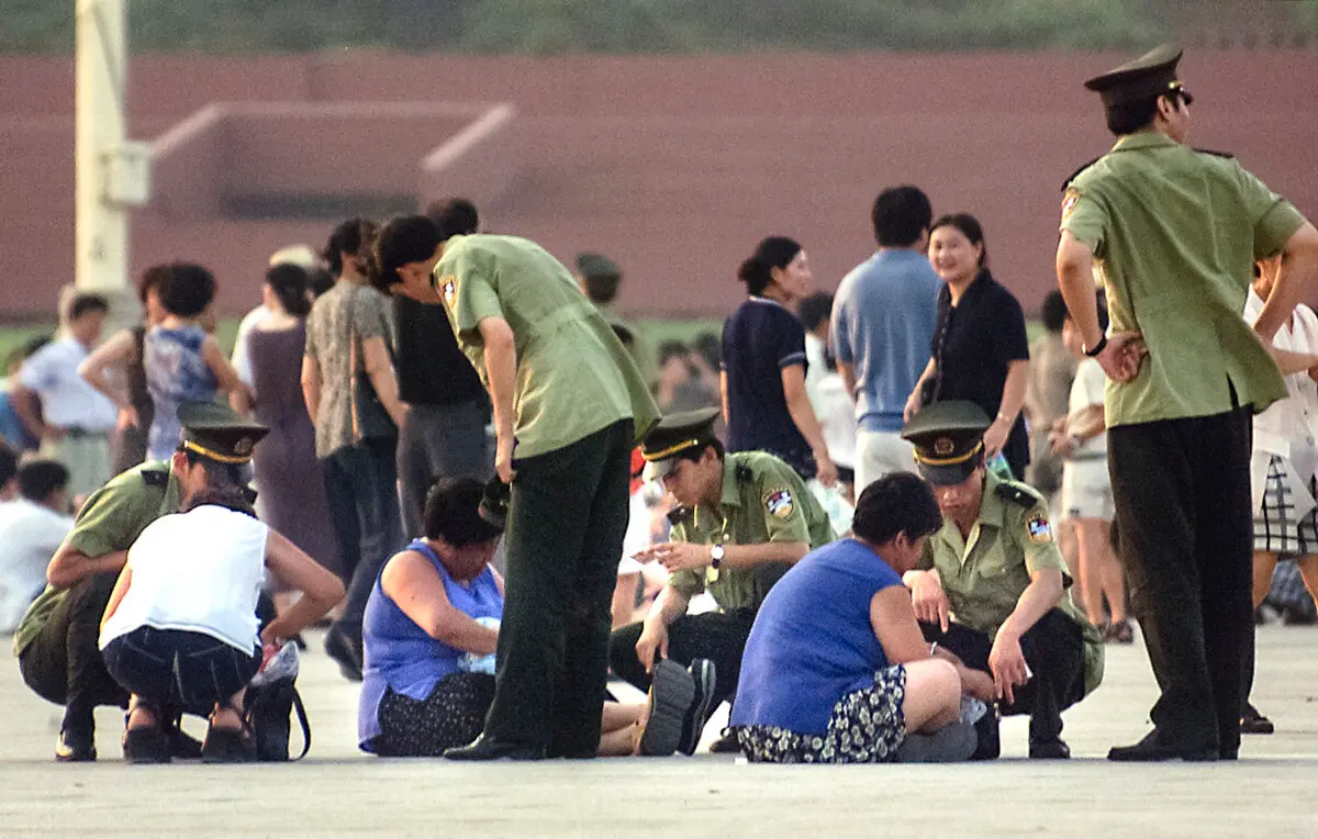 La policía china detiene a varias mujeres sospechosas de ser practicantes de Falun Gong en la plaza de Tiananmen, en Pekín, el 23 de julio de 1999. (Stephen Shaver/AFP a través de Getty Images).
