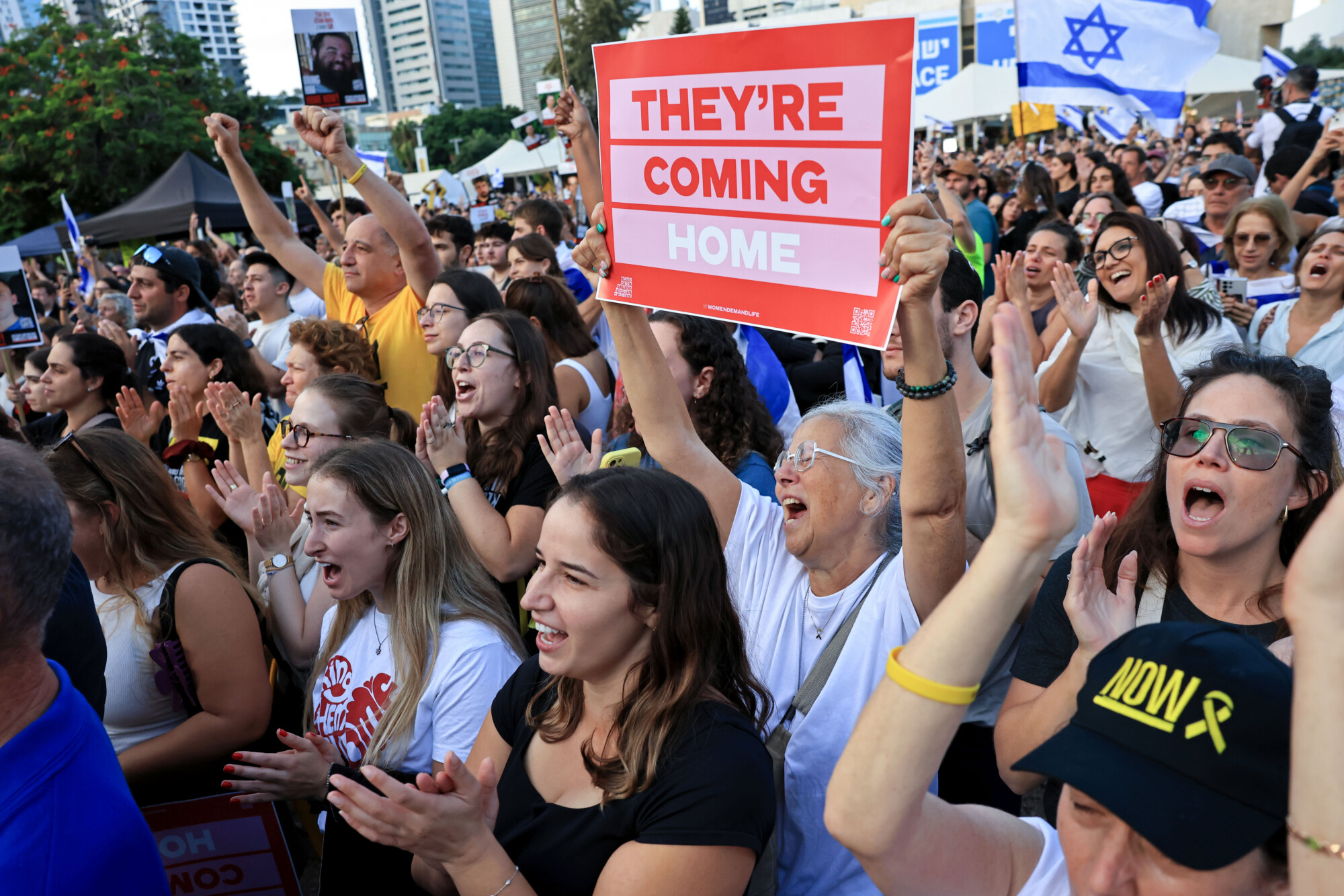 La gente ve la retransmisión en directo de la liberación de los rehenes en la plaza Hostages Square de Tel Aviv el 13 de octubre de 2025. (Foto de Chris McGrath/Getty Images)