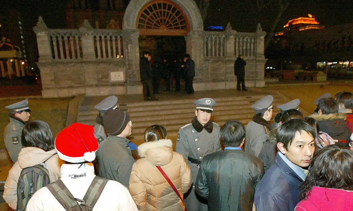 <em>Guardias de seguridad y policías chinos mantienen a cientos de fieles cristianos chinos alejados de la Iglesia Católica de Wangfujing durante la misa de Navidad en Beijing el 25 de diciembre de 2003. (Goh Chai Hin/AFP vía Getty Images)</em>