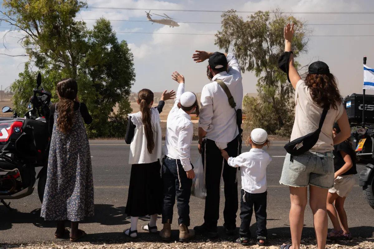 <em>Israelíes se reúnen con banderas nacionales frente a la base militar de Reim, cerca de la frontera con Gaza, en el sur de Israel, para dar la bienvenida a los rehenes que estaban a punto de llegar tras su liberación por Hamás de la Franja de Gaza el 13 de octubre de 2025. (MAYA LEVIN/AFP vía Getty Images)</em>