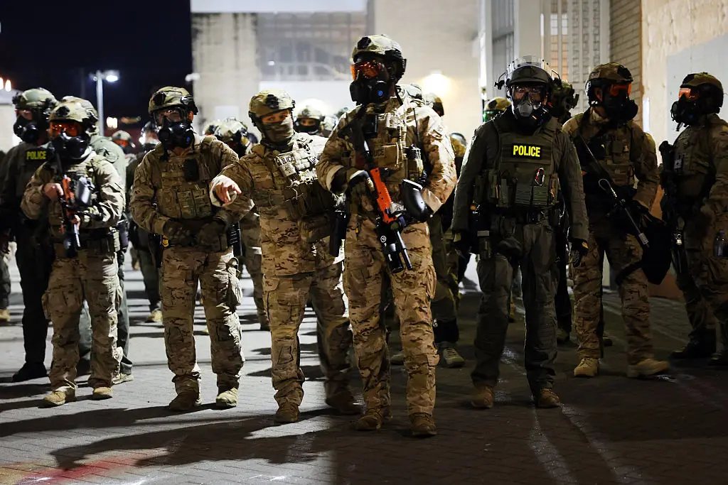 Agentes federales, entre ellos miembros del Departamento de Seguridad Nacional, la Patrulla Fronteriza y la policía, intentan mantener a los manifestantes fuera de las instalaciones del Servicio de Inmigración y Control de Aduanas de Estados Unidos en Portland, Oregón, el 5 de octubre de 2025. (Spencer Platt/Getty Images).