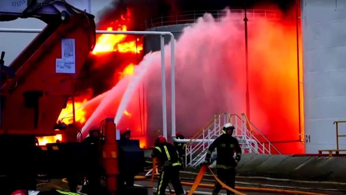 Los bomberos trabajan para extinguir un incendio en una instalación de almacenamiento de combustible en Lviv, Ucrania, el 27 de marzo de 2022. (Reuters/Captura de pantalla vía The Epoch Times)