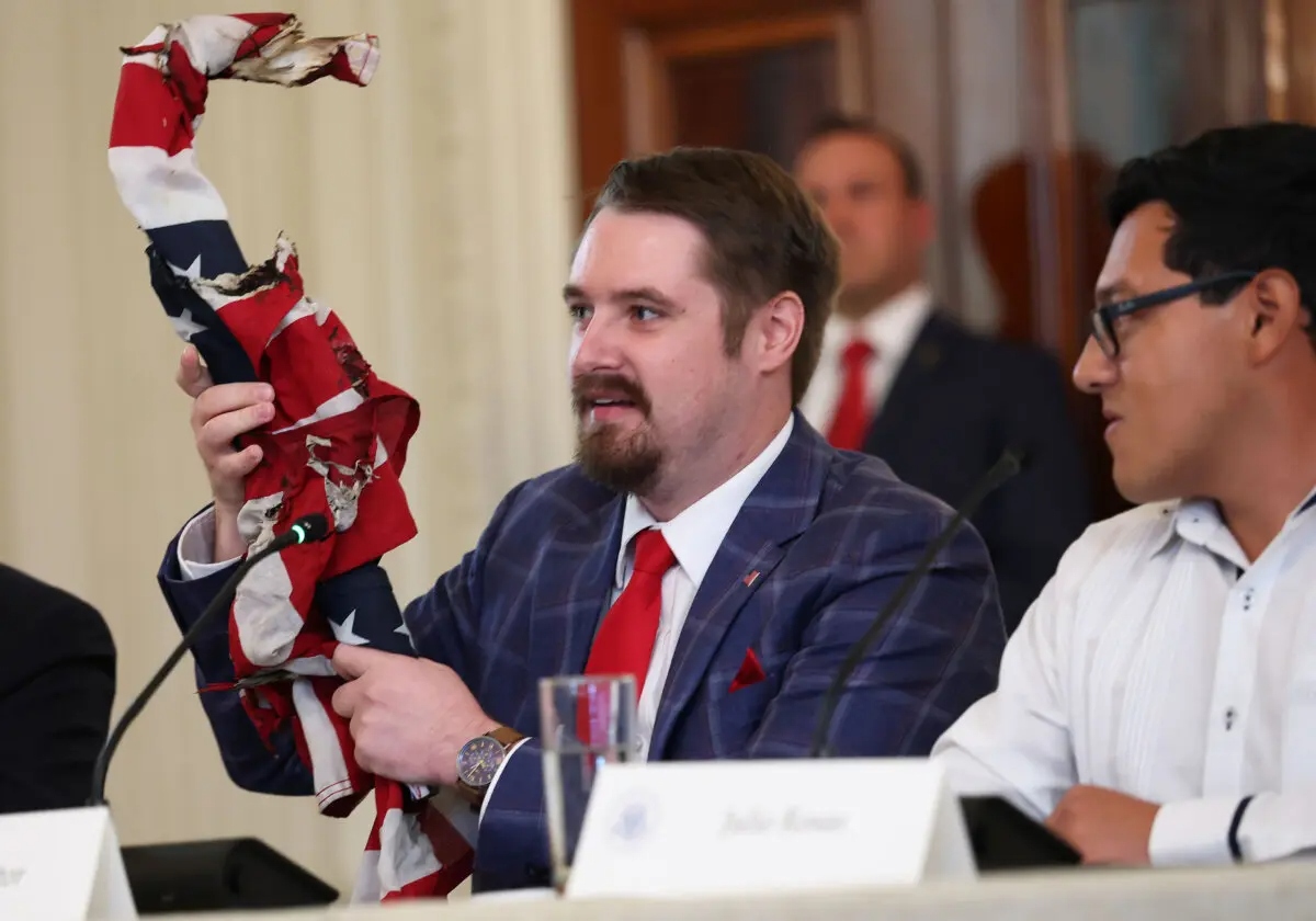 El influencer conservador Nick Sortor sostiene una bandera estadounidense recuperada de las protestas en Portland, Oregón, durante una mesa redonda en el Comedor de Estado de la Casa Blanca, en Washington, el 8 de octubre de 2025. (Anna Moneymaker/Getty Images)