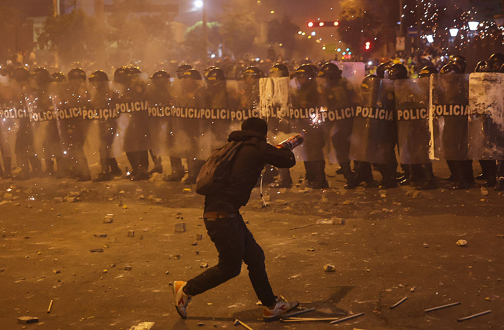 Un manifestante lanza fuegos artificiales contra agentes de la policía antidisturbios durante los enfrentamientos posteriores a una protesta contra el presidente interino de Perú, José Jeri, en Lima el 15 de octubre de 2025. (Foto de HUGO CUROTTO/AFP vía Getty Images)