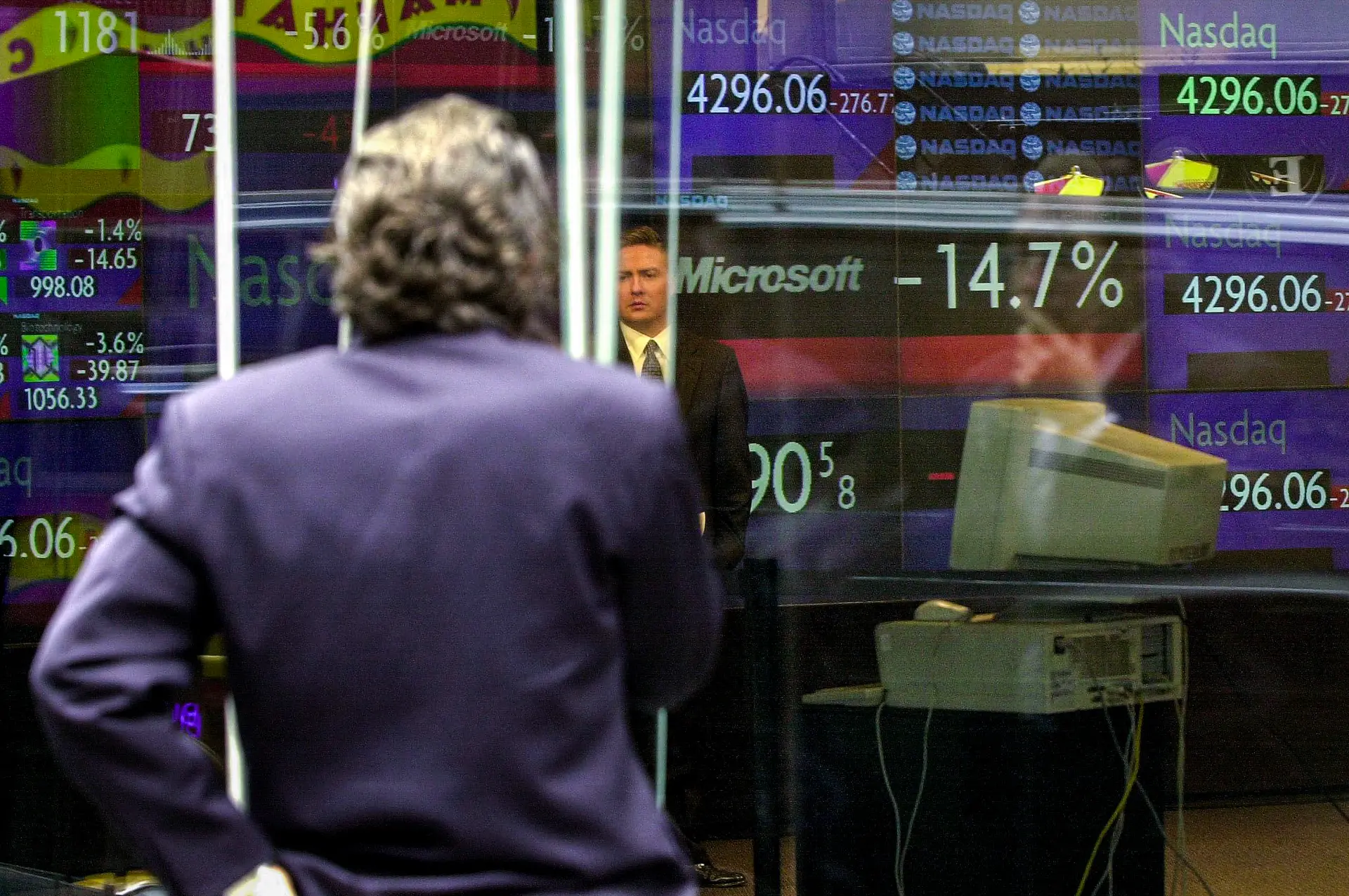 Los espectadores comprueban las cifras de cotización tanto de Microsoft, que en ese momento había bajado un 14.7 por ciento, como de la bolsa NASDAQ, en la sala de operaciones del NASDAQ Marketsite en Times Square, Nueva York, el 3 de abril de 2000. La última vez que los mercados estuvieron tan concentrados fue durante el apogeo de la burbuja puntocom en 2000. (Henny Ray Abrams/AFP a través de Getty Images)