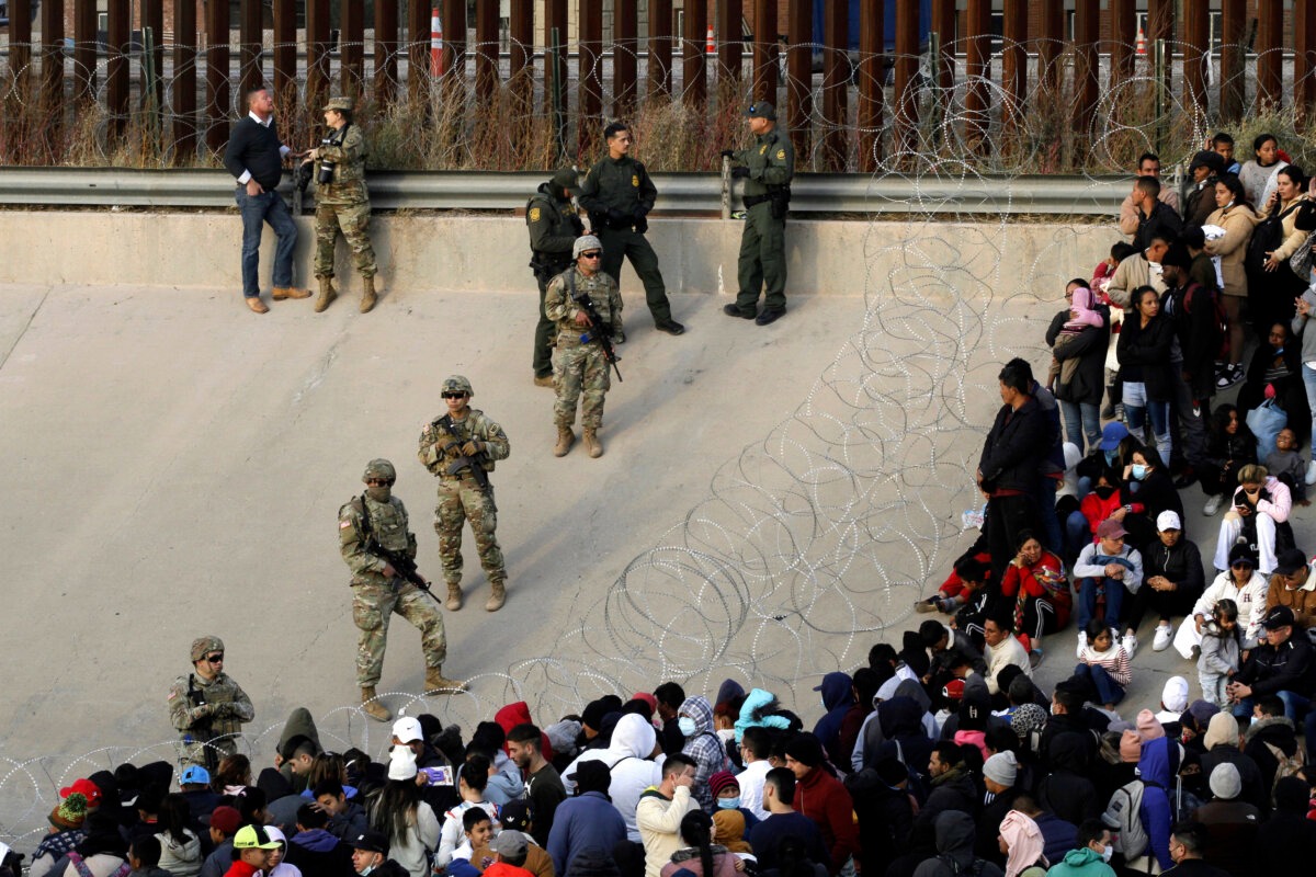 Los migrantes se congregan a orillas del Río Grande, en la frontera entre Estados Unidos y México, el 20 de diciembre de 2022, donde miembros de la Guardia Nacional de Texas acordonaron un hueco en el muro fronterizo estadounidense. (Morgan Lee/AP Photo).