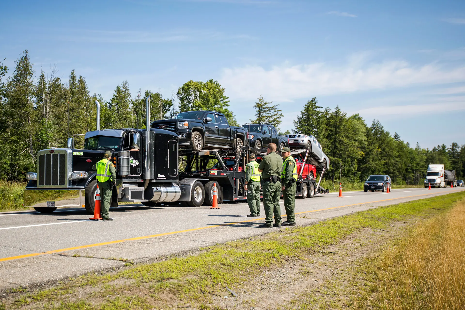 Agentes de la Patrulla Fronteriza de EE. UU. observan cómo un camión entra en un puesto de control de la autopista en West Enfield, Maine, el 1 de agosto de 2018. Un análisis de la revista Overdrive estima que hay unos 60,000 titulares de licencias comerciales "sin domicilio" activo que trabajan pero no viven en Estados Unidos. (Scott Eisen/Getty Images).