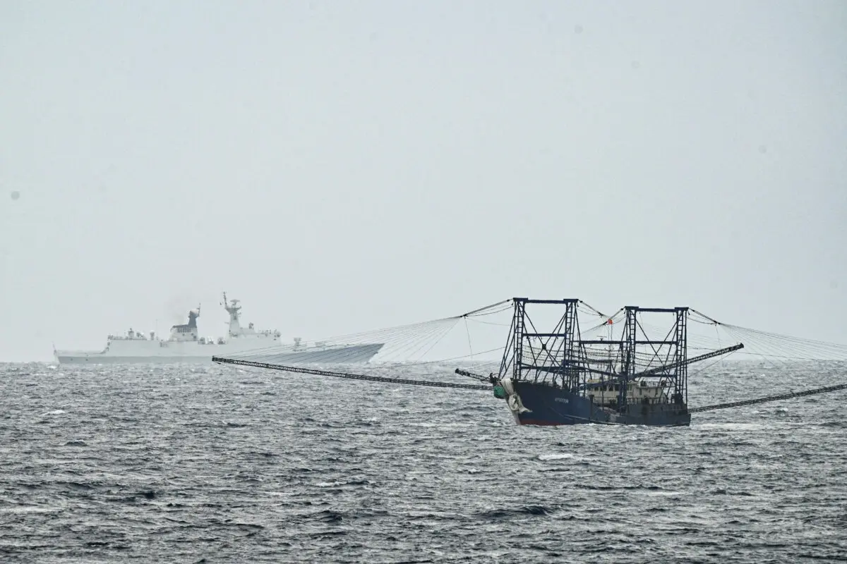 <em>Un buque de la armada china con el número de proa 525 adelanta a un buque chino, visto desde el buque de la armada filipina Andrés Bonifacio cerca de la isla de Thitu, ocupada por Filipinas, durante una patrulla marítima en el disputado Mar de China Meridional el 6 de junio de 2025. (Ted Aljibe/AFP vía Getty Images)</em>
