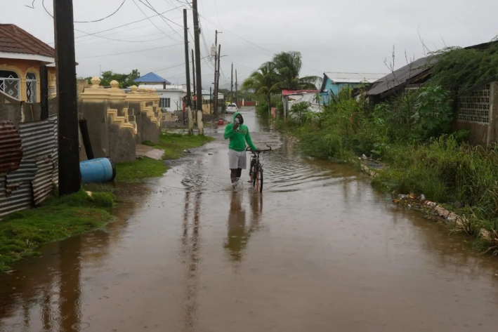 Un hombre camina por una calle inundada antes de la llegada prevista del huracán Melissa en Old Harbour, Jamaica, el 27 de octubre de 2025. (AP Photo/Matias Delacroix)