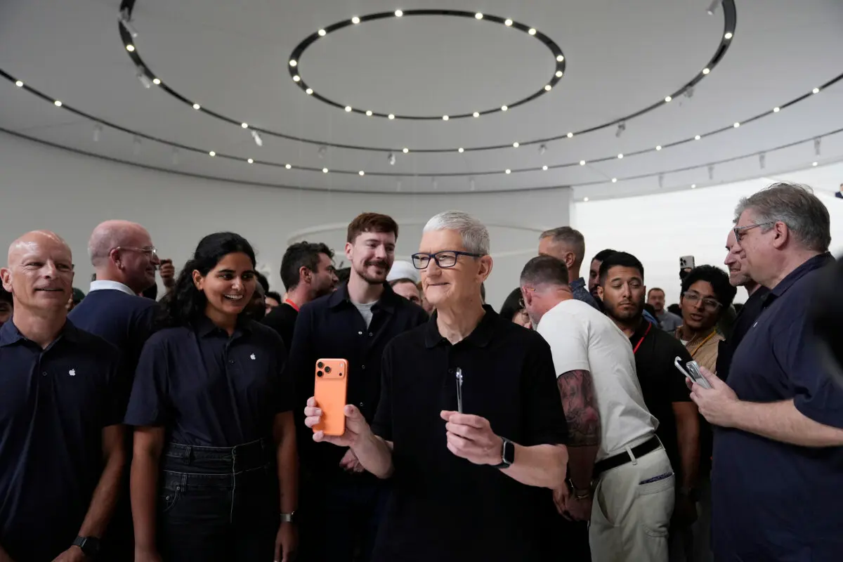 El director ejecutivo de Apple, Tim Cook, sostiene los nuevos iPhone durante la presentación de nuevos productos en el Apple Park de Cupertino, California, el 9 de septiembre de 2025. (AP Photo/Godofredo A. Vásquez).