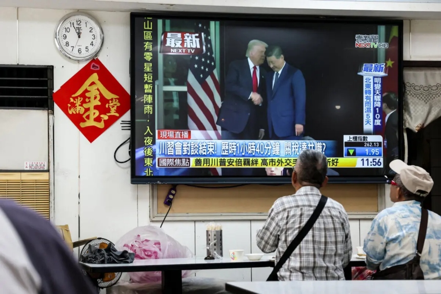 La gente ve un programa de noticias en Taipéi que muestra imágenes de la reunión entre el presidente Donald Trump y el líder chino Xi Jinping en Corea del Sur, el 30 de octubre de 2025. (I-Hwa Cheng/AFP a través de Getty Images)