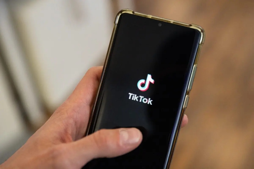 Un hombre sostiene un teléfono inteligente con el logotipo de TikTok en una oficina de París, el 19 de abril de 2024. (Antonin Utz/AFP a través de Getty Images)