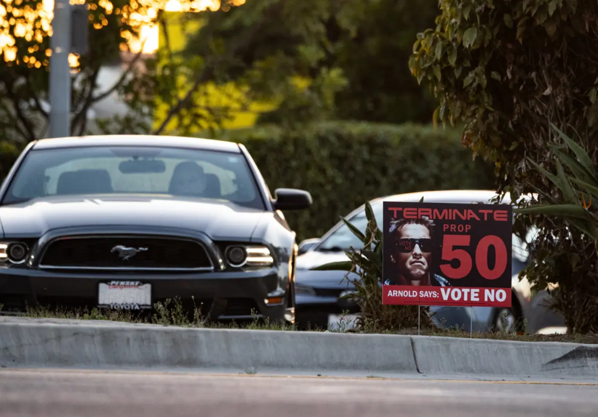 <em>El tráfico circula frente a un cartel que se opone a la Proposición 50 de California en Los Ángeles, el 28 de octubre de 2025. (John Fredricks/The Epoch Times)</em>