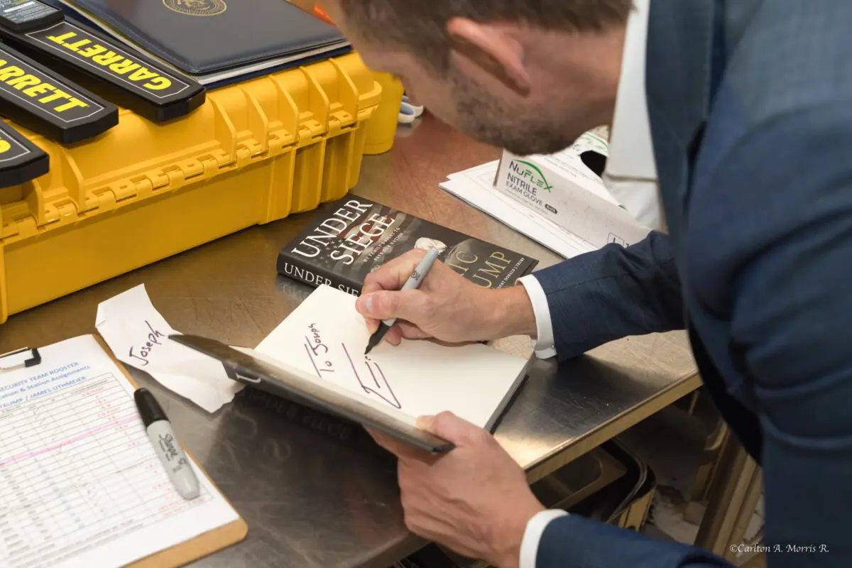 Eric Trump firma ejemplares de su nuevo libro "Bajo asedio: la lucha de mi familia para salvar nuestra nación", en el Club 47 USA, un club de fans de Trump, en West Palm Beach, Florida, el 3 de noviembre de 2025. (Cortesía de Carlton A. Morris)