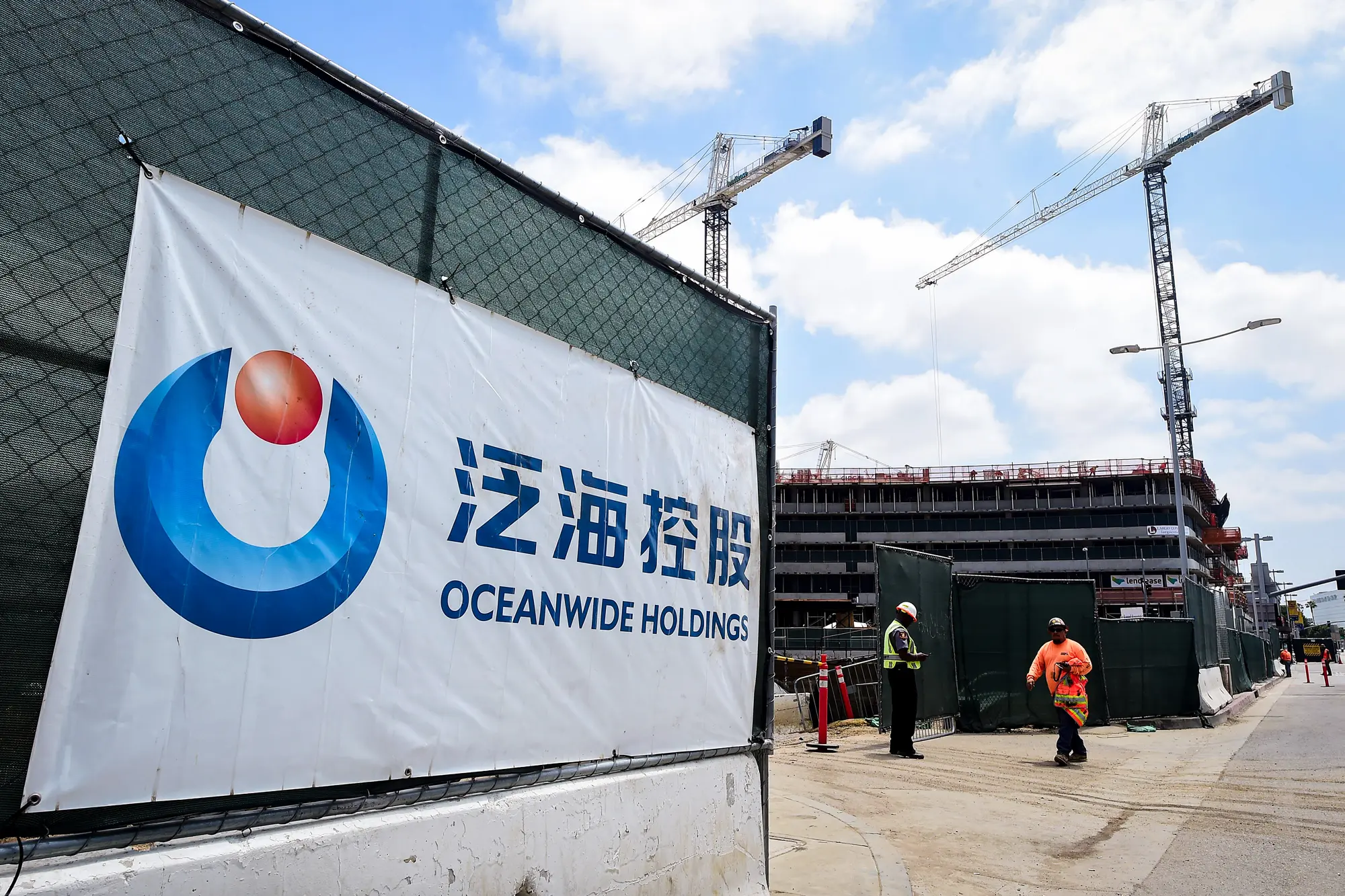 <em>Un cartel de la empresa china Oceanwide Real Estate Group se exhibe en su obra frente al Staples Center de Los Ángeles el 17 de mayo de 2016. Los chinos adinerados son una base de clientes clave para las redes de lavado de dinero, ya que mueven fondos para la compra de inmuebles y el pago de matrículas universitarias en Estados Unidos, eludiendo al mismo tiempo los estrictos controles de divisas y capitales de China. Frederic J. Brown/AFP a través de Getty Images</em>