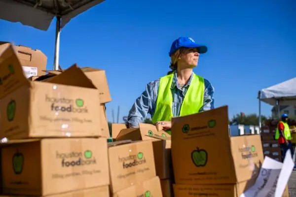 Un voluntario prepara cajas de alimentos en el estadio NRG de Houston el 1 de noviembre de 2025. (Mark Felix/AFP a través de Getty Images)