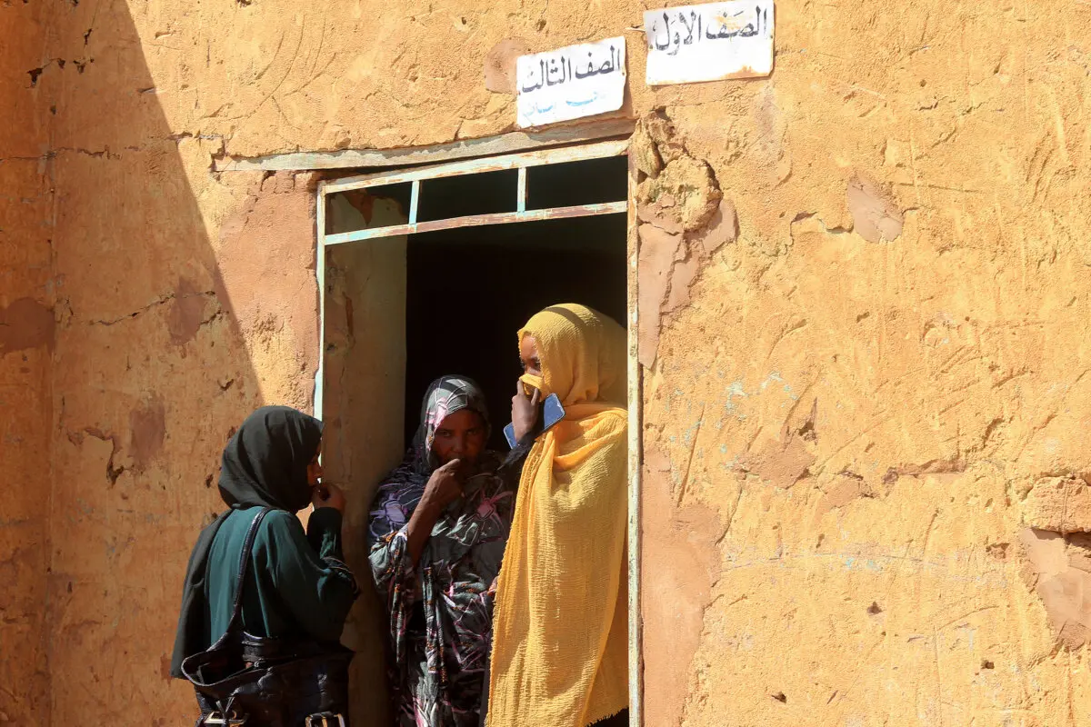 Tres mujeres, que forman parte de un grupo de personas desplazadas de las localidades de Bara y Umm Dam Haj Ahmed, en el estado de Kordofán del Norte, se refugian en Omdurman, en el área metropolitana de Jartum, el 10 de noviembre de 2025. (Ebrahim Hamid/AFP).