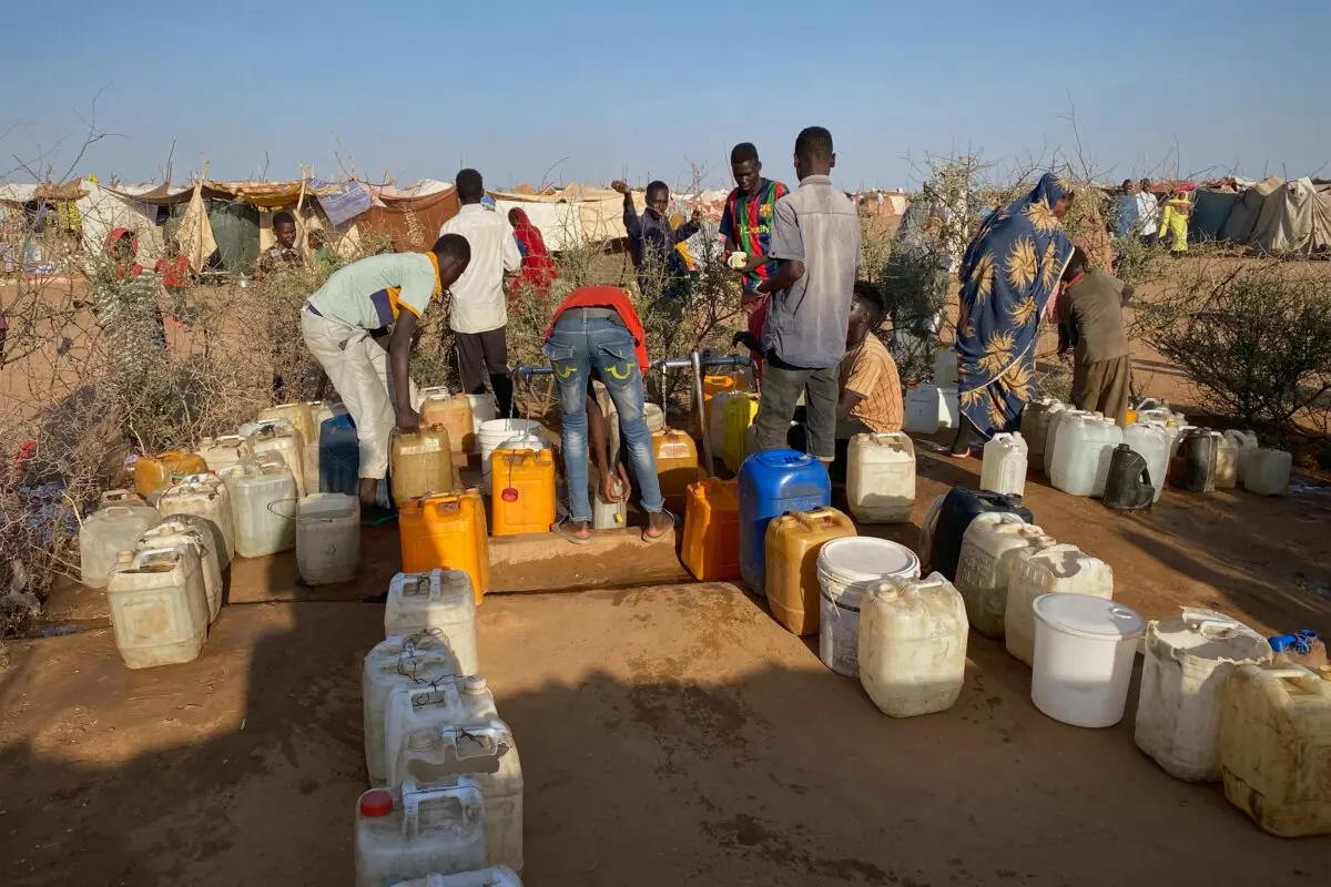 Hombres sudaneses que huyeron de la ciudad de El Fasher, después de que las fuerzas paramilitares de Sudán mataran a cientos de personas en la región occidental de Darfur, recogen agua en un campamento en Tawila, Sudán, el sábado 1 de noviembre de 2025. (Foto AP/Mohammed Bakry).