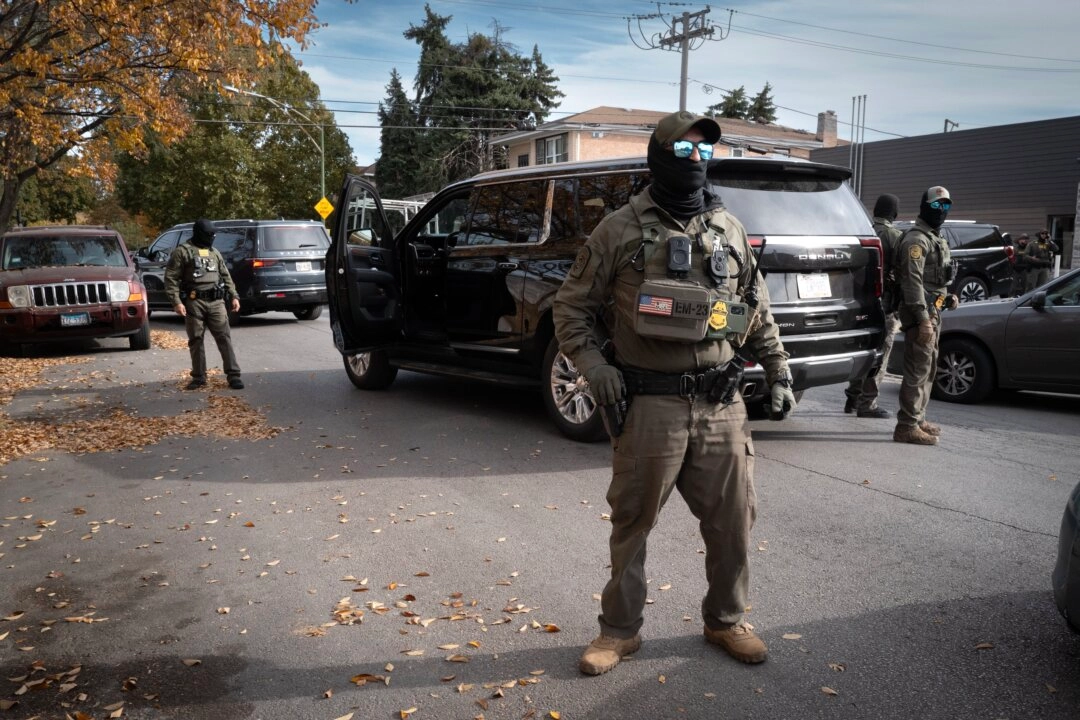<em>Agentes federales montan guardia mientras son increpados por residentes tras detener una caravana que circulaba por el barrio de Brighton Park en Chicago, Illinois, el 6 de noviembre de 2025. (Foto de Scott Olson/Getty Images)</em>