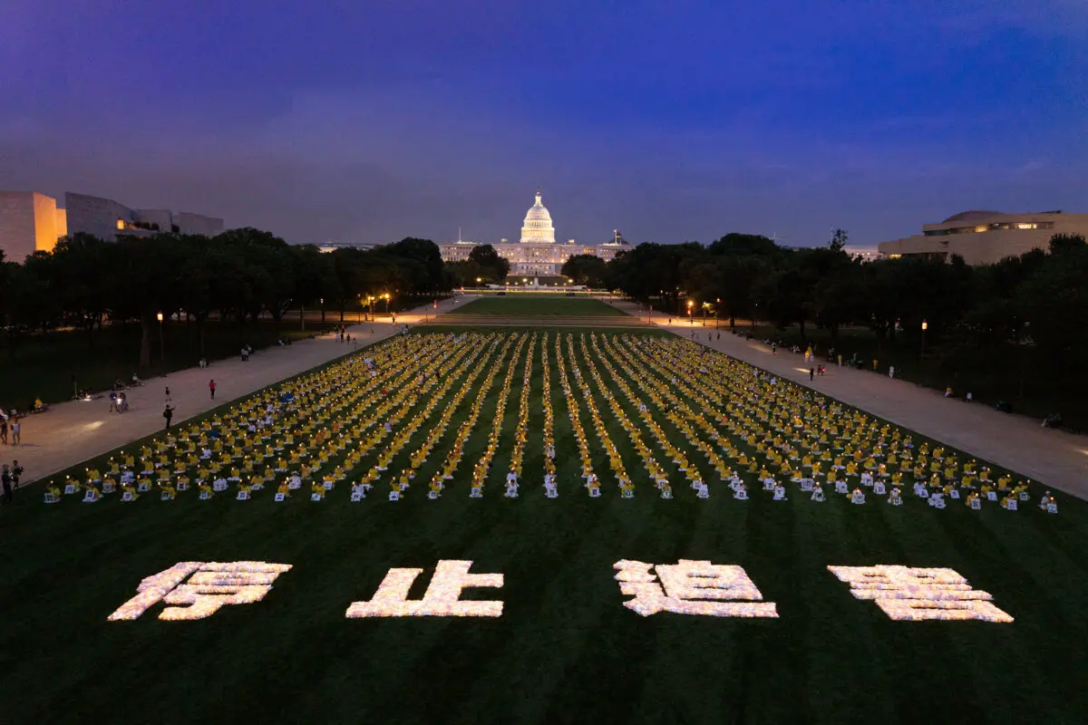 Practicantes de Falun Gong participan en una vigilia con velas en conmemoración de sus compañeros practicantes que fueron perseguidos hasta la muerte por el Partido Comunista Chino en China, en Washington, el 17 de julio de 2025. (Larry Dye/The Epoch Times)