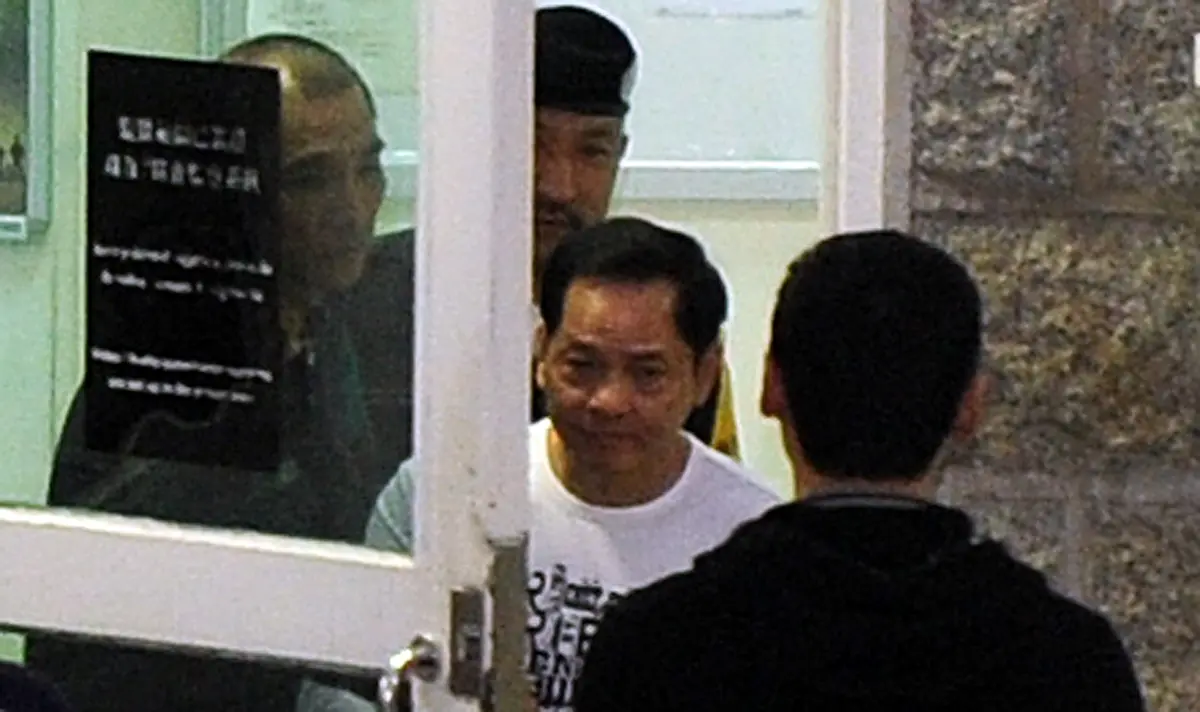 <em>Wan Kuok-koi (con camisa blanca), también conocido como "Broken Tooth", sale de una prisión en Macao el 1 de diciembre de 2012. (Laurent Fievet/AFP a través de Getty Images)</em>